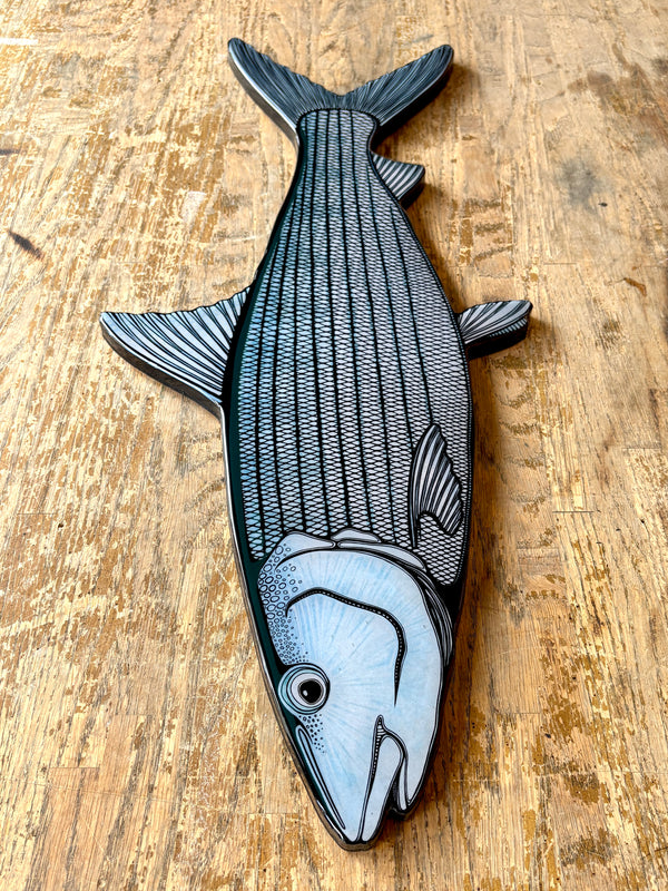 Decorative fish wall art on a wooden surface