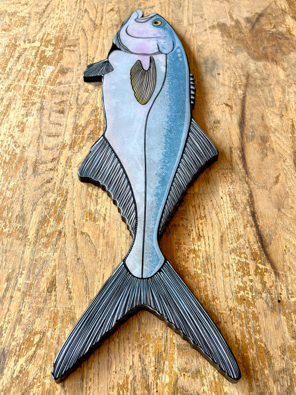 Decorative fish-shaped object on a wooden surface