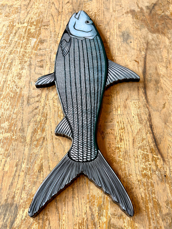 Decorative fish-shaped object on a wooden surface
