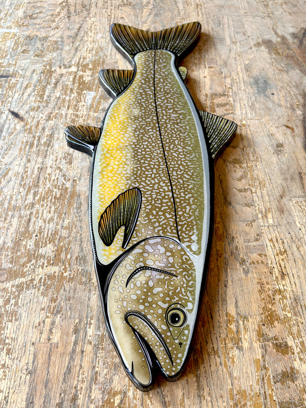 Decorative fish-shaped object on a wooden surface