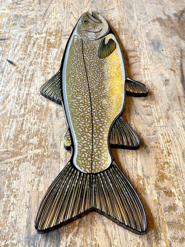 Decorative fish-shaped object on a wooden surface